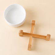 Close-up detail of the ceramic bowl with crossed wood stand — white 400 ml