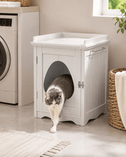 Cat using the hidden litter box cabinet — white