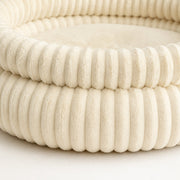 Close-up detail of the ribbed plush bolster bed — cream large